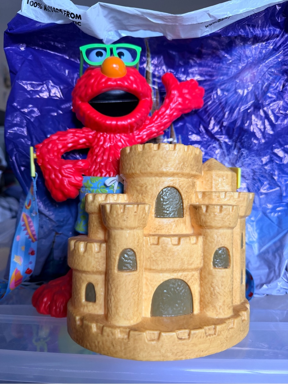 Sesame Street Elmo Red Figure with Green Glasses and Yellow popcorn bucket.